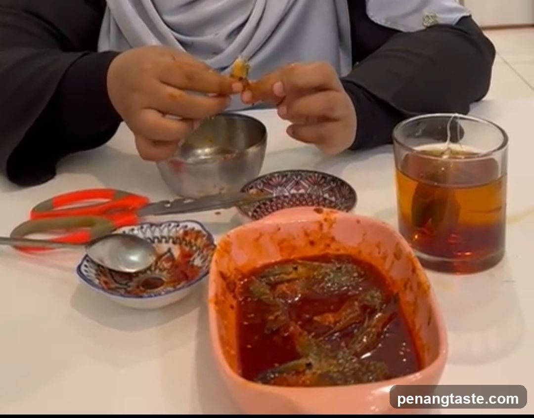 Person eating fish in sauce with tea