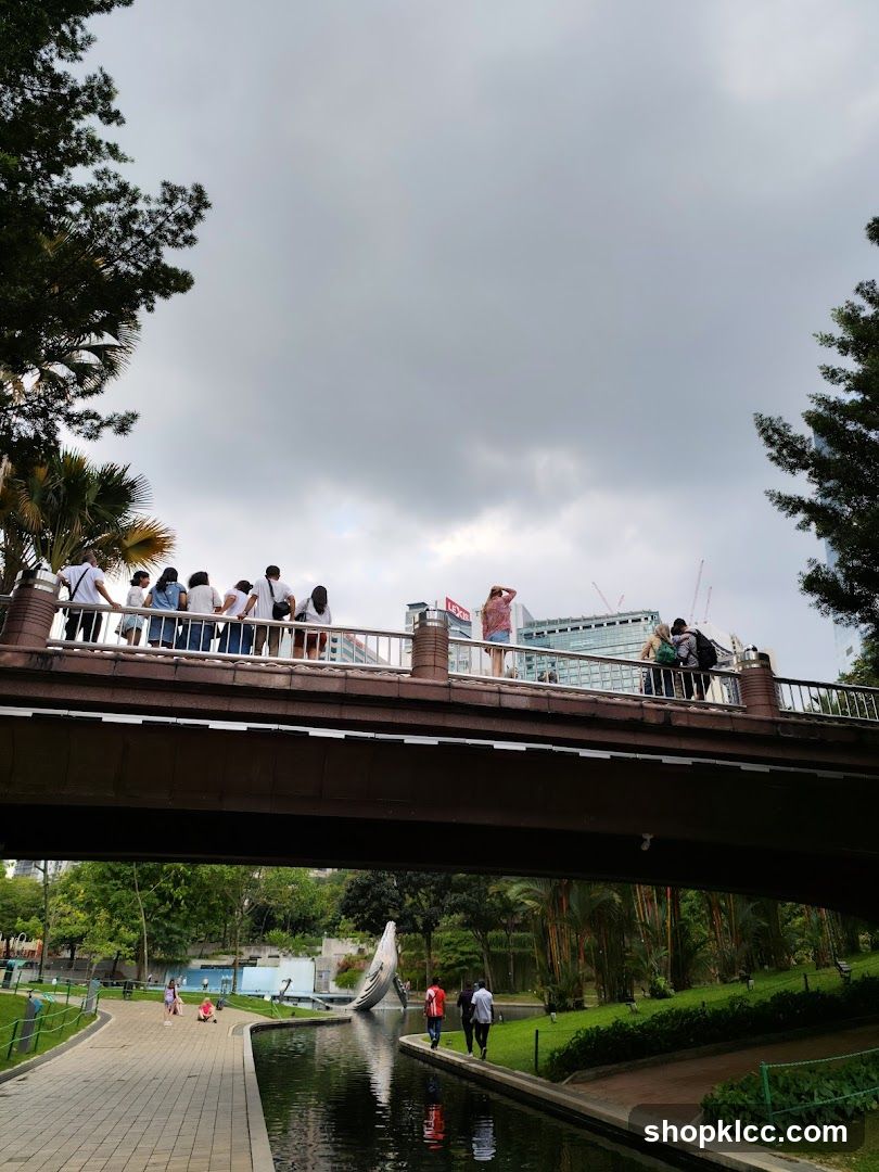 People on a bridge over a park with a canal