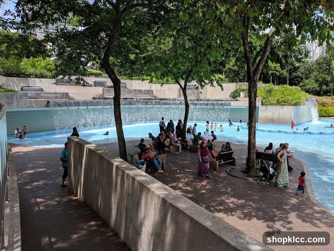 People enjoying a public pool with waterfalls