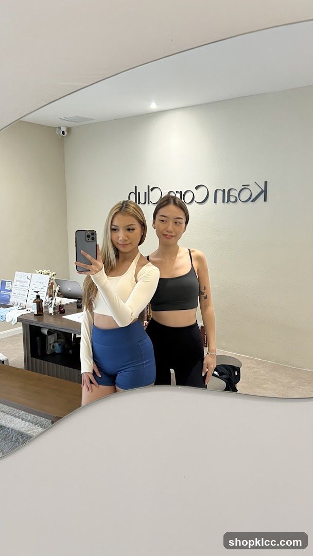 Two women taking a mirror selfie in a studio