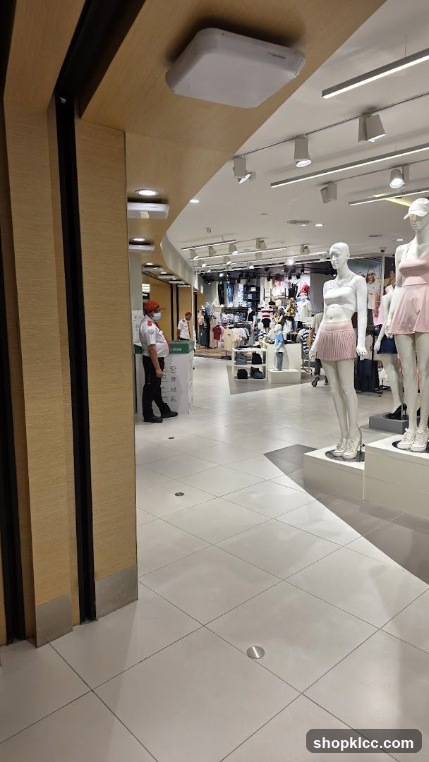Clothing store interior with mannequins and security guard
