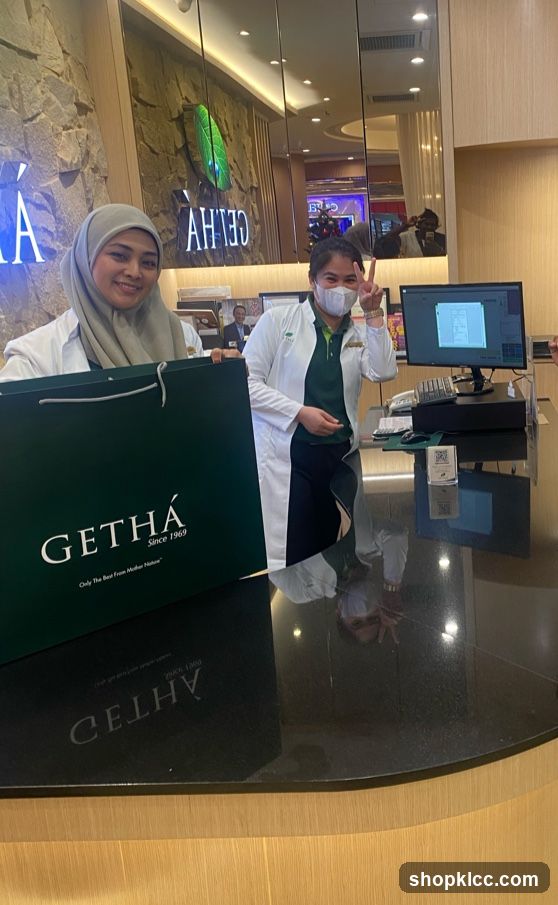 Two women in lab coats holding a shopping bag