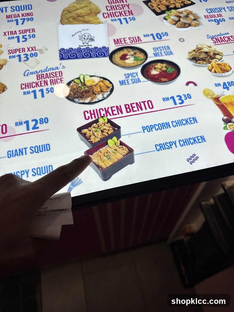 A close-up of a digital menu board displaying various chicken and rice dishes with prices in RM.