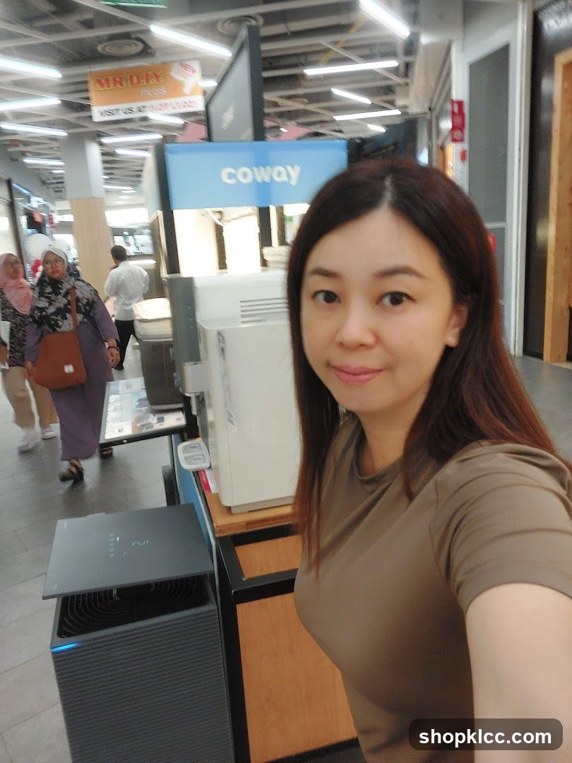 Woman posing in front of Coway display