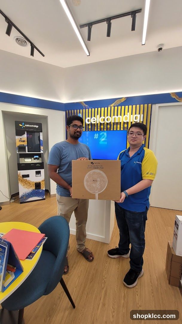 Two men holding a box with a fan inside