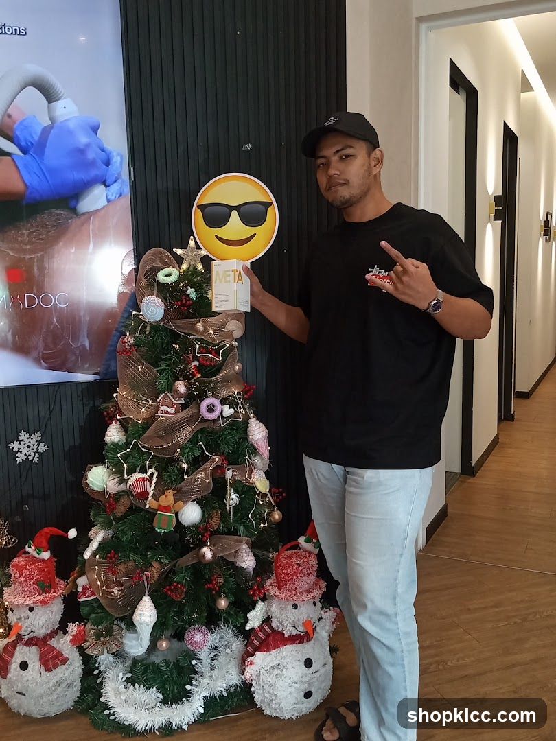Man holding a product box next to a Christmas tree