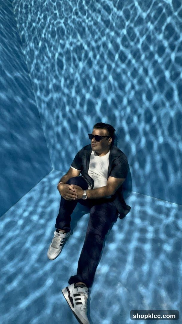Man sitting in a room with water-like light projections