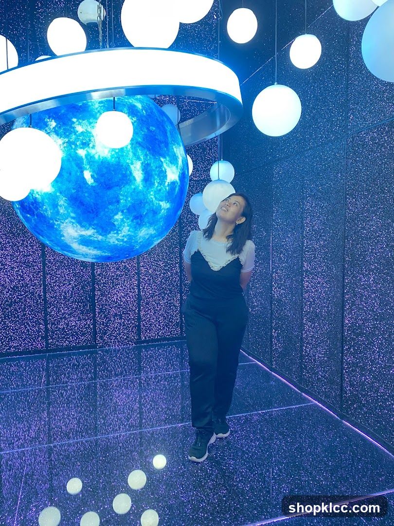 Woman in a room with a large blue sphere and lights