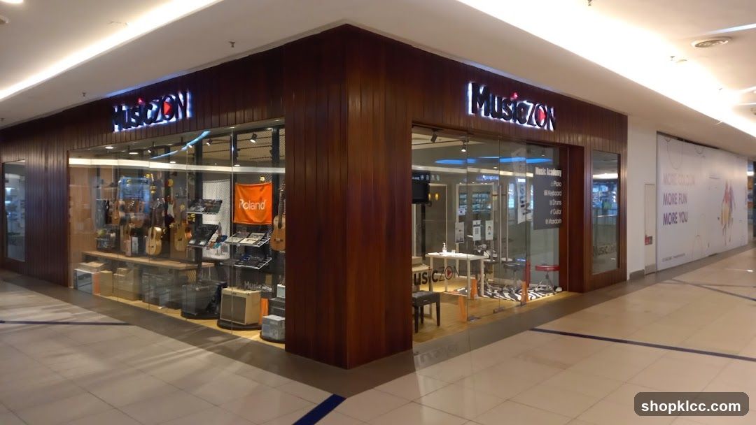 The exterior of a music store with large glass windows displaying musical instruments like guitars and keyboards. The store's name, "MUSICZON," is visible in illuminated signage above the entrance. Inside, there are displays of instruments, amplifiers, and a small table with chairs. A sign for "Music Academy" lists courses such as Piano, Keyboard, Drums, Guitar, and Marimba.