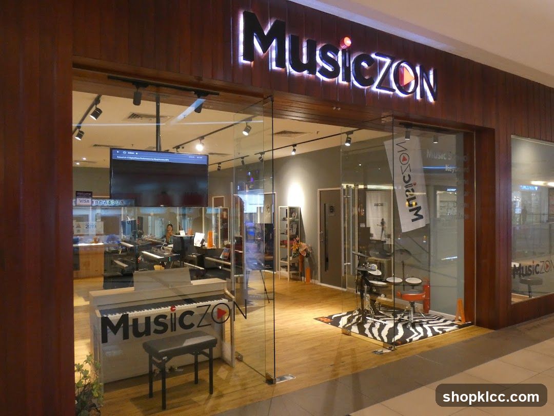 The exterior of a music store called MusicZON. The store has a large glass facade, allowing a view into the interior where musical instruments, including pianos and drums, are displayed. A prominent illuminated sign above the entrance reads "MusicZON". Inside, a large screen displays content, and a digital piano with the store's logo is visible near the entrance.
