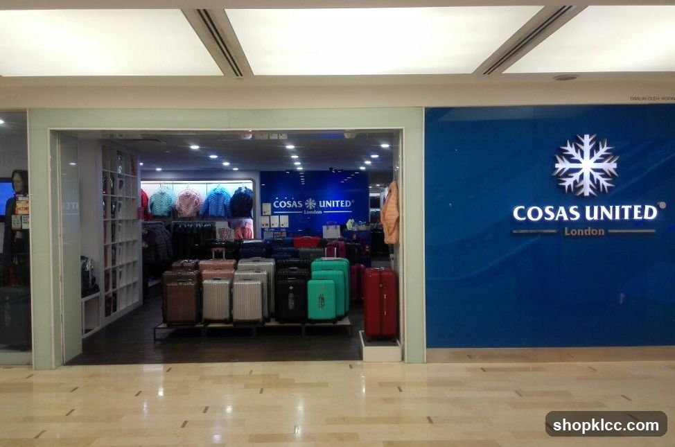 The exterior of a store with a large blue wall featuring the "Cosas United London" logo and a snowflake emblem. To the left, the store entrance is visible, showcasing a display of luggage and clothing racks with jackets.