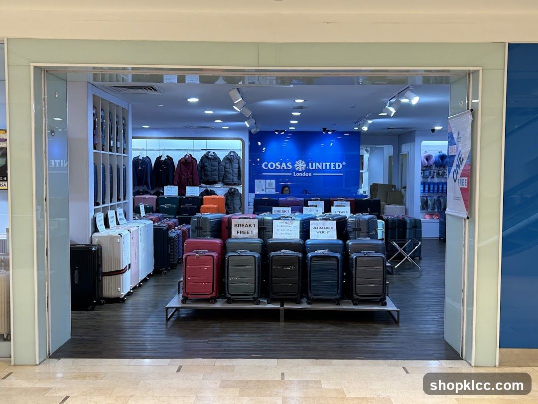 The image shows the interior of a luggage store, viewed from an entrance. The store displays a variety of suitcases in different sizes and colors. In the background, a blue wall features the store's logo, "COSAS UNITED London". There are also racks of jackets and shelves with travel accessories. Signs indicating "BREAK 1 FREE 1" and "ULTRA LIGHT WEIGHT" are visible.