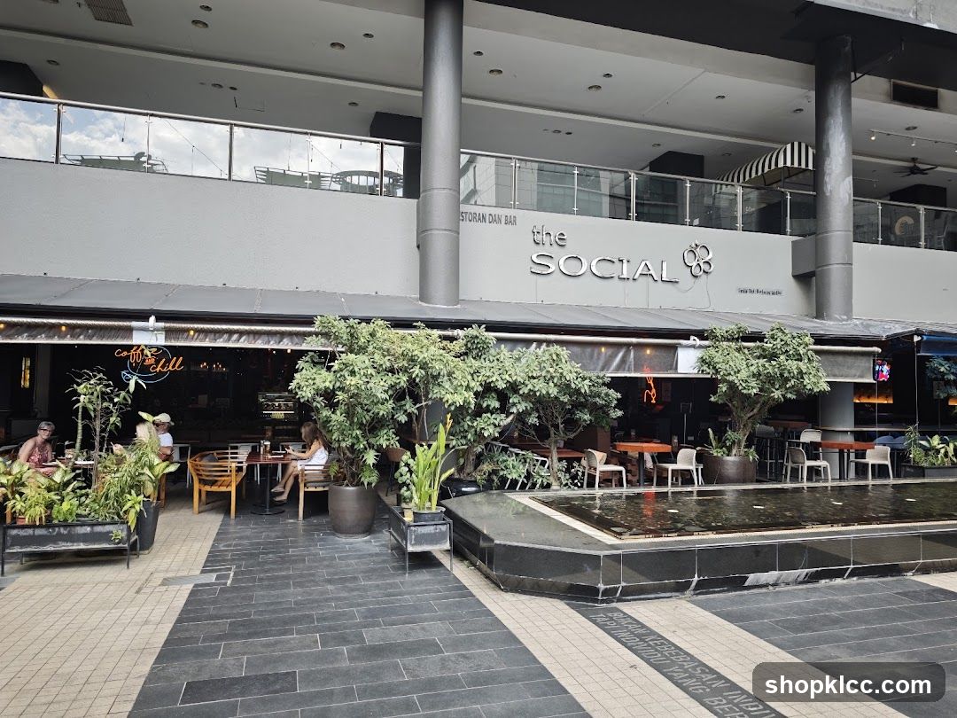 The exterior of a restaurant and bar called "The Social" is visible, with outdoor seating areas and a water feature in the foreground. The building has a modern facade with large windows and signage.