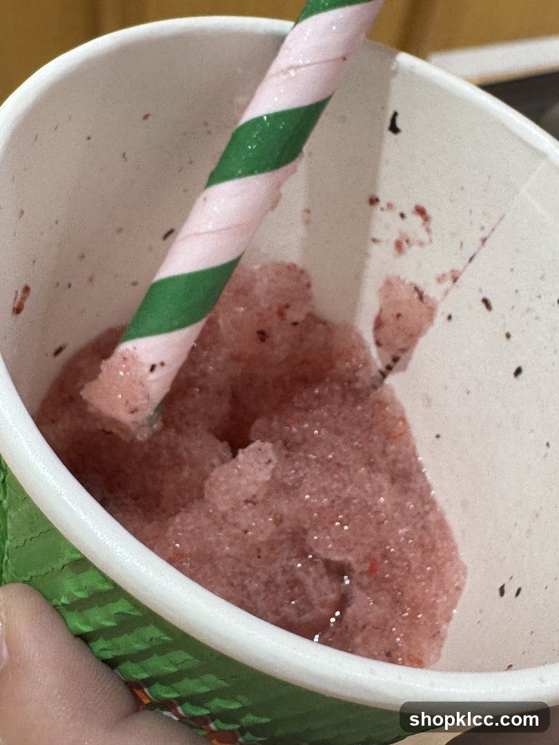 Close-up of a pink slushy with a striped straw