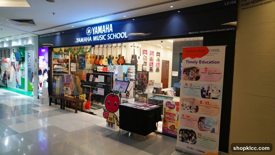 The exterior of a Yamaha Music School store, featuring a prominent sign with the Yamaha logo and "YAMAHA MUSIC SCHOOL" text. The storefront displays various musical instruments, including guitars and keyboards, as well as educational materials and promotional banners.