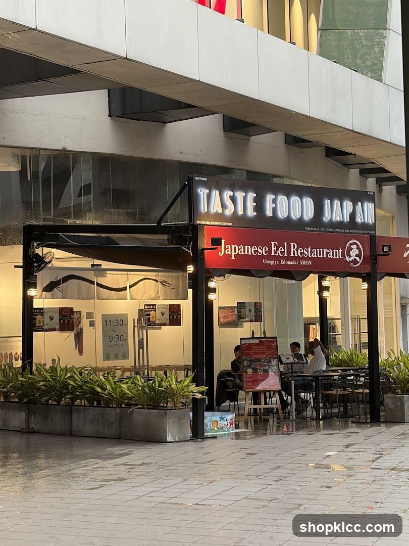 The exterior of a Japanese eel restaurant with prominent signage. The restaurant is called "TASTE FOOD JAPAN" and also "Japanese Eel Restaurant Unagiya Edonadai AMON". The operating hours are displayed as 11:30 AM to 9:30 PM.