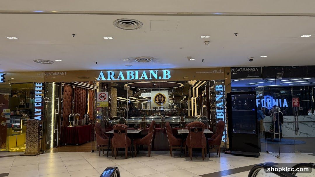 The exterior of a restaurant called Arabian.B, with a sign above the entrance. The restaurant has a luxurious interior with velvet chairs and ornate decorations. Buffet stations are visible inside, with food under chafing dishes. To the left, there is a section for "ITALY COFFEE". To the right, another establishment with the word "FORNIA" is visible.