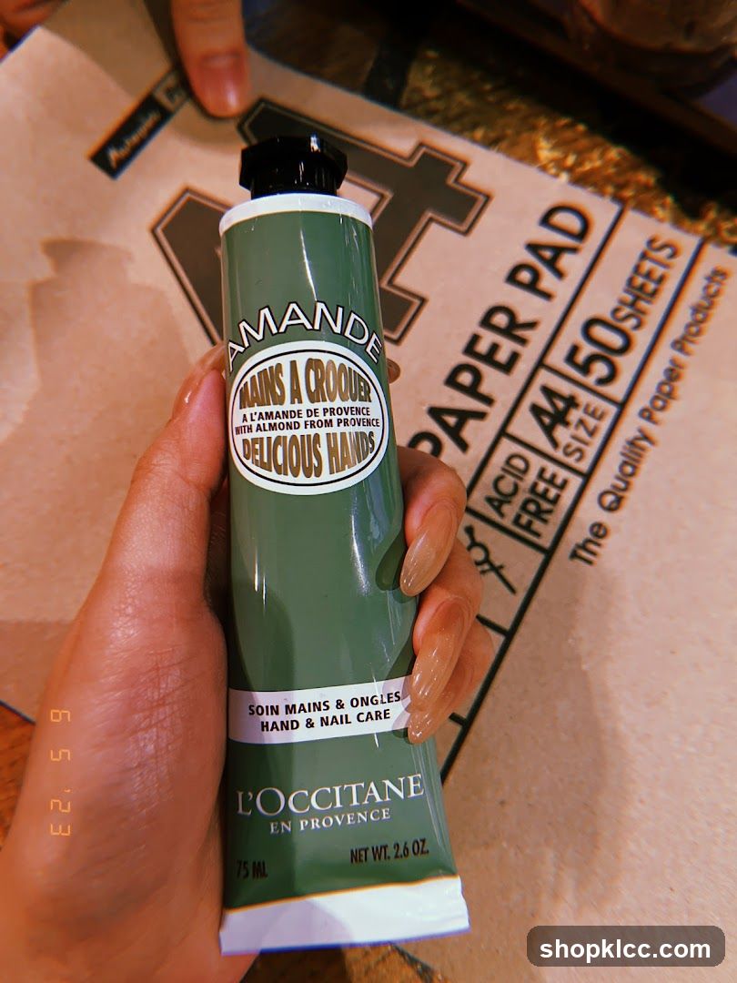 Hand holding L'Occitane hand cream