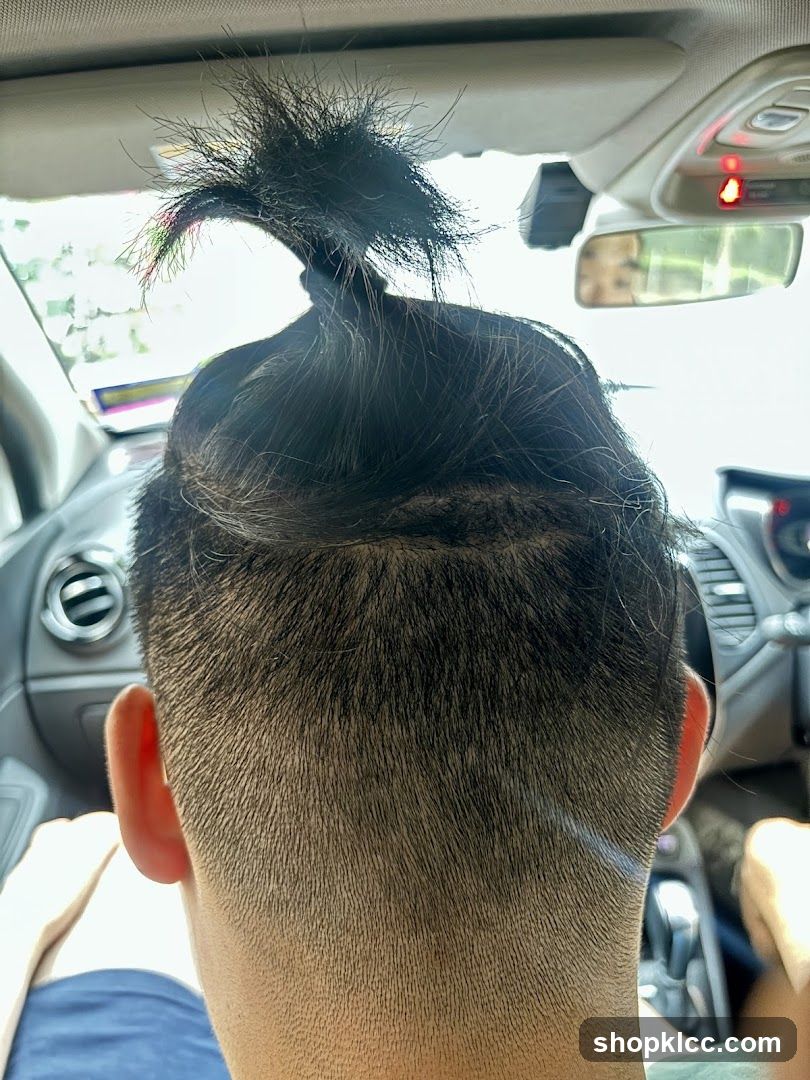 Man with a top knot in a car