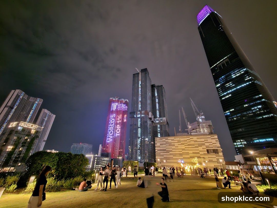 Cityscape at Night with Illuminated Buildings and People