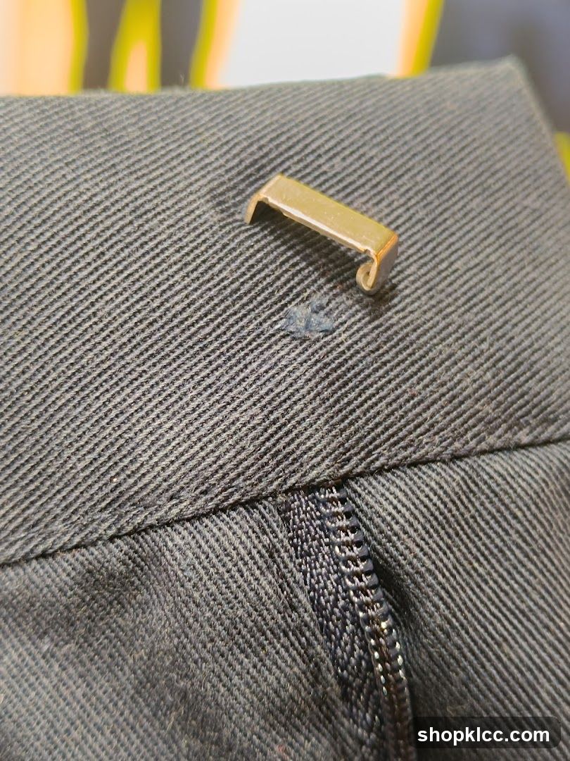 Close-up of a Zipper and Button Tab on Dark Fabric