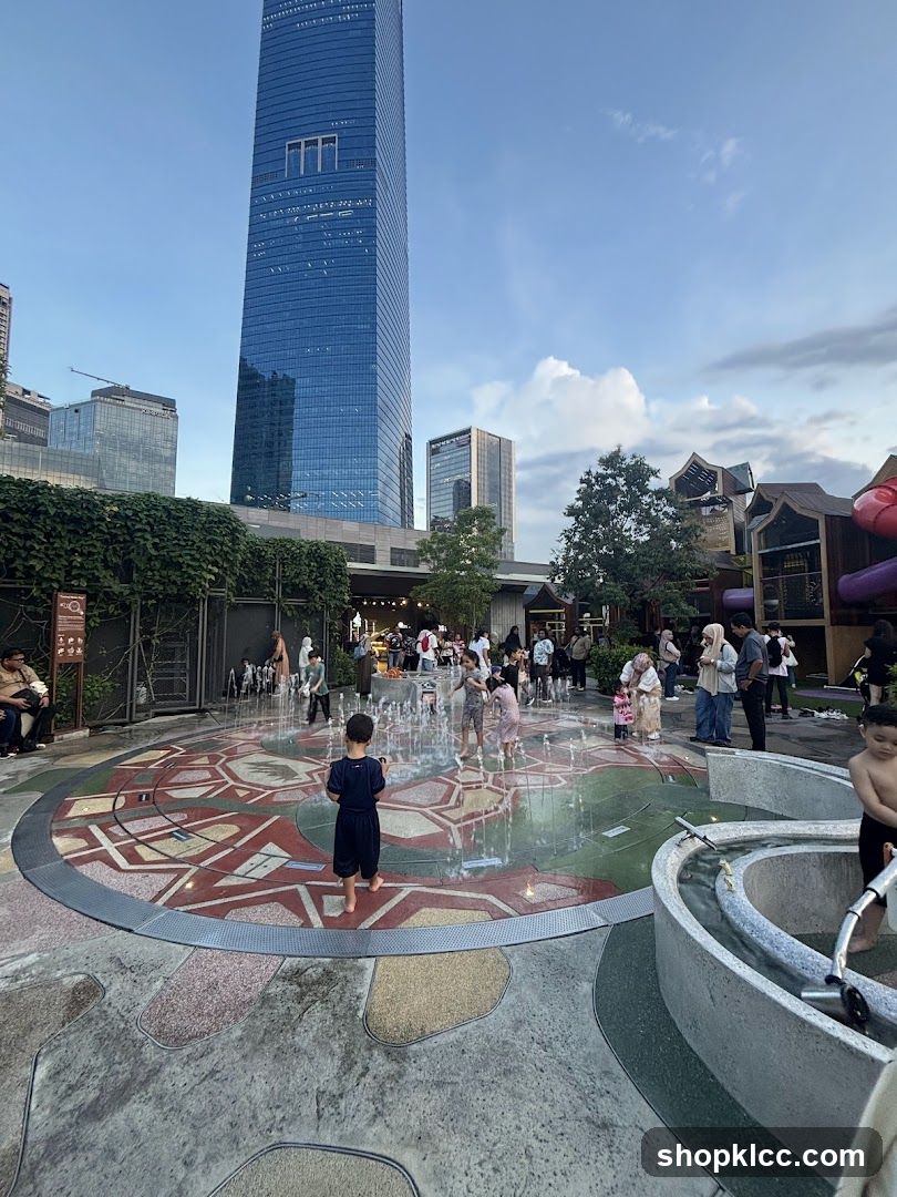 Children playing in a water fountain area with skyscrapers in the background