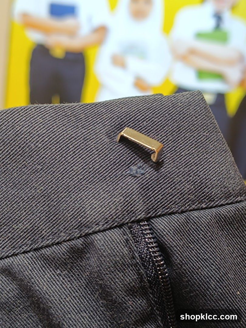 Close-up of dark fabric with a metal clasp and zipper