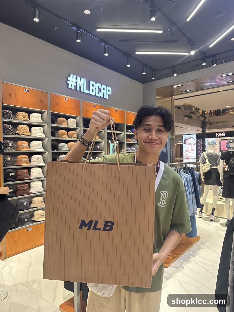 Man holding an MLB shopping bag in a store