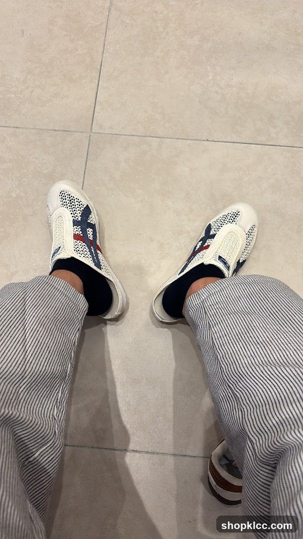 Person Wearing White Slip-On Shoes and Striped Pants