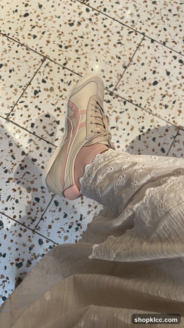 Beige and pink sneakers on a person's foot