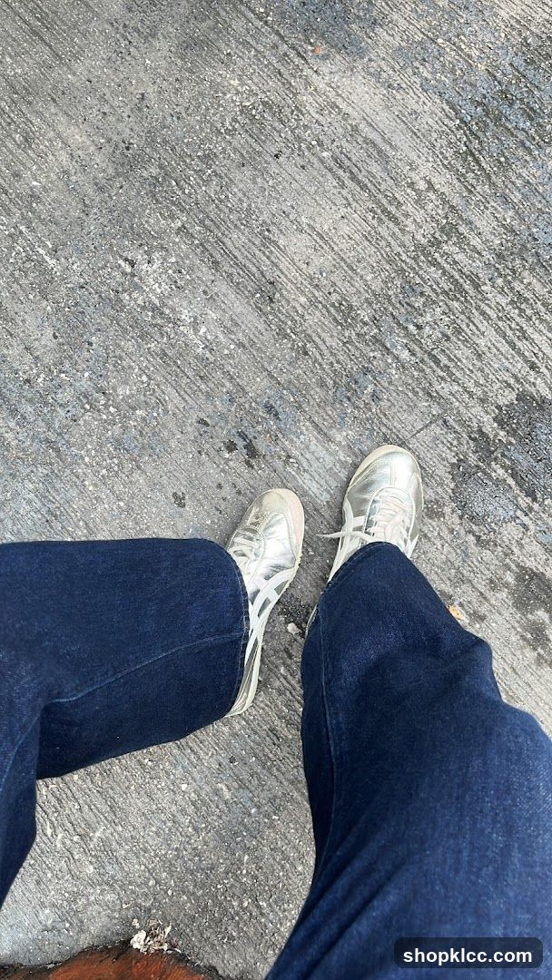 Person wearing silver sneakers and blue jeans