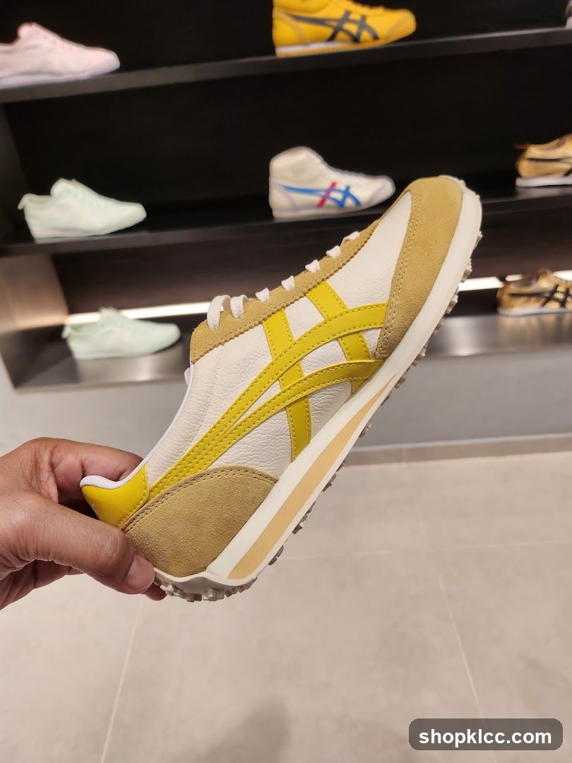 Hand holding a yellow and white sneaker