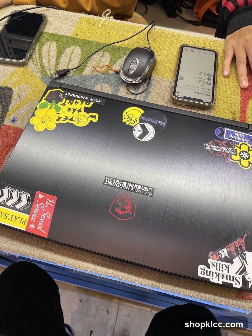 Laptop with stickers on table