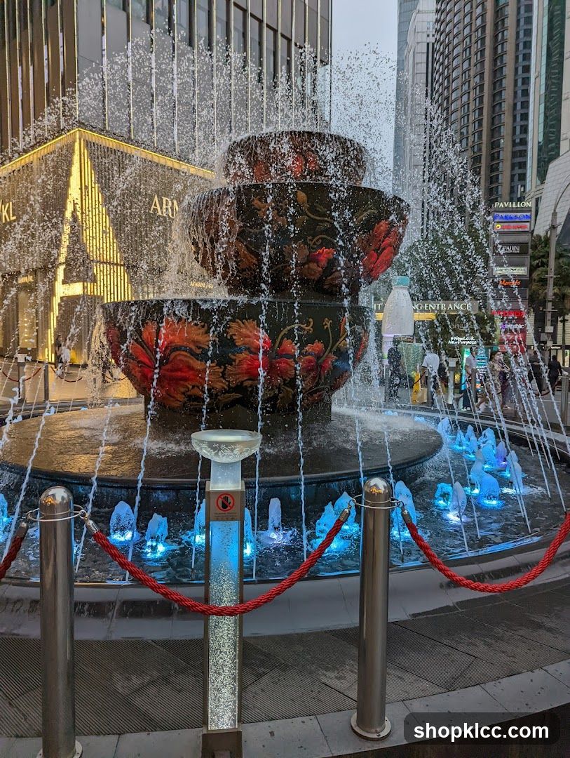 Fountain with illuminated water jets and surrounding urban buildings