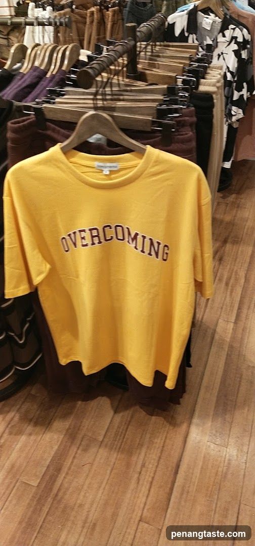 Yellow T-shirt with "OVERCOMING" text