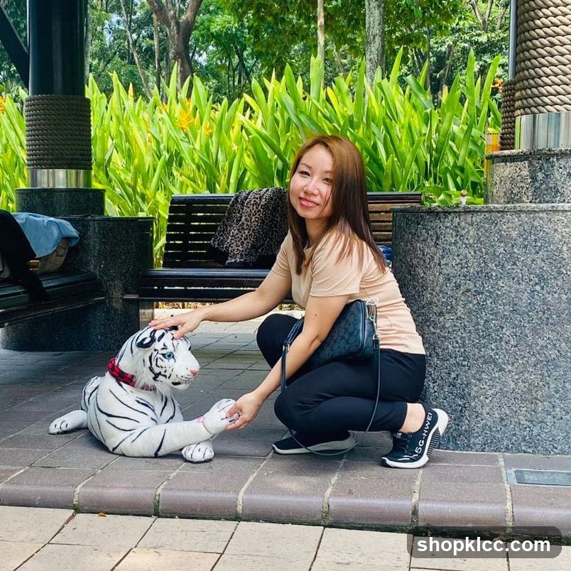 Woman petting a white tiger statue in a park