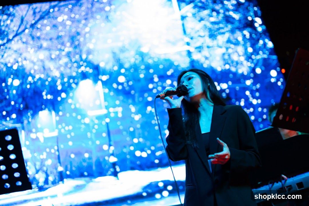 Singer performing on stage with blue lighting backdrop