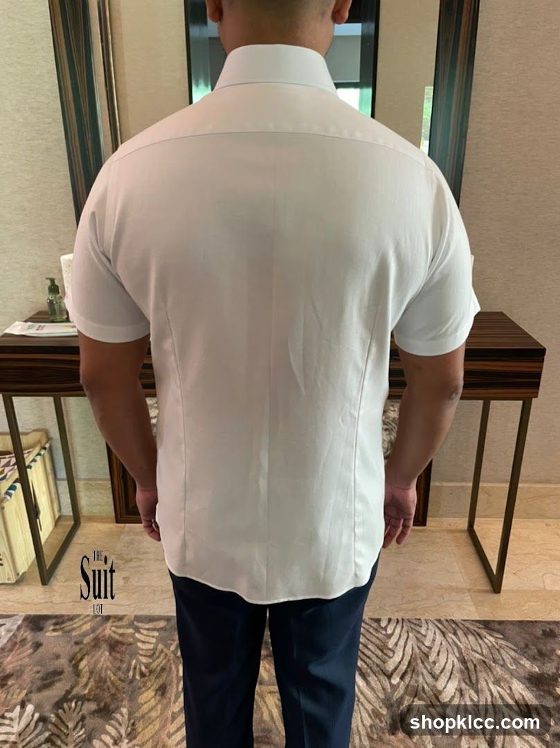 Man wearing white shirt and dark pants indoors
