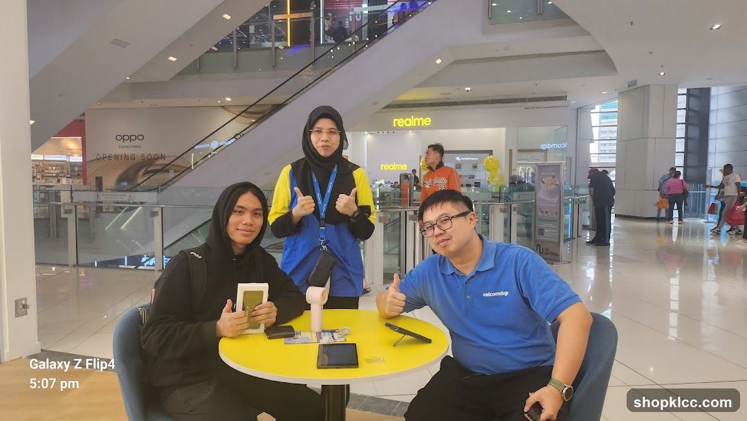 People posing at a table in a mall
