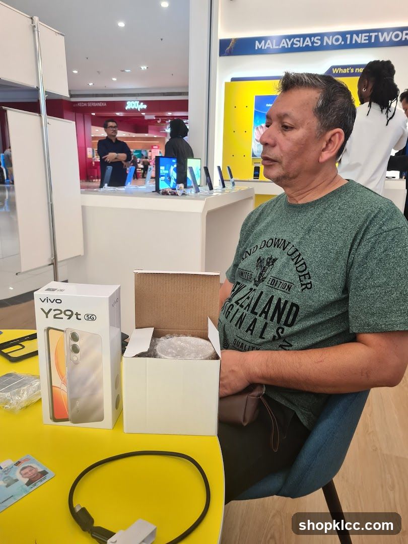 Man sitting at a table with a new phone