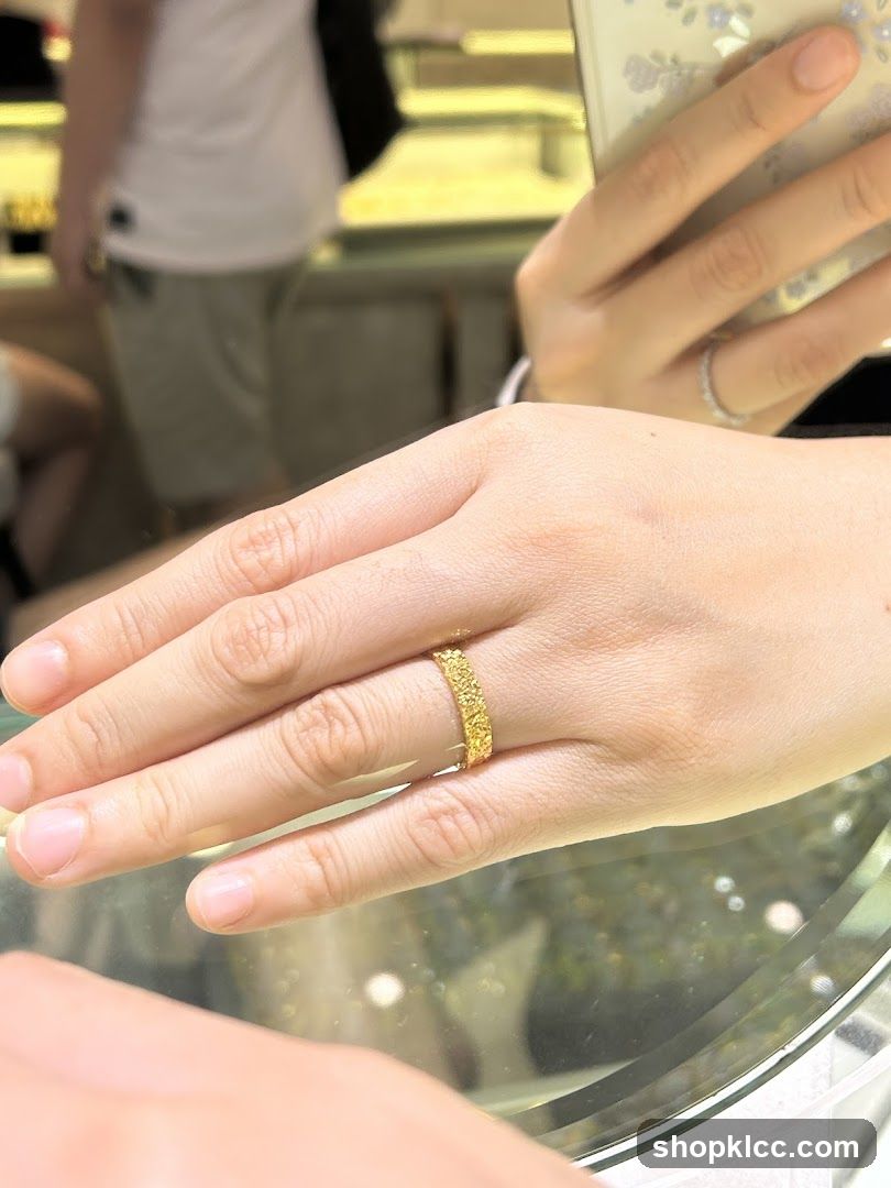 Close-up of a hand wearing a textured gold ring