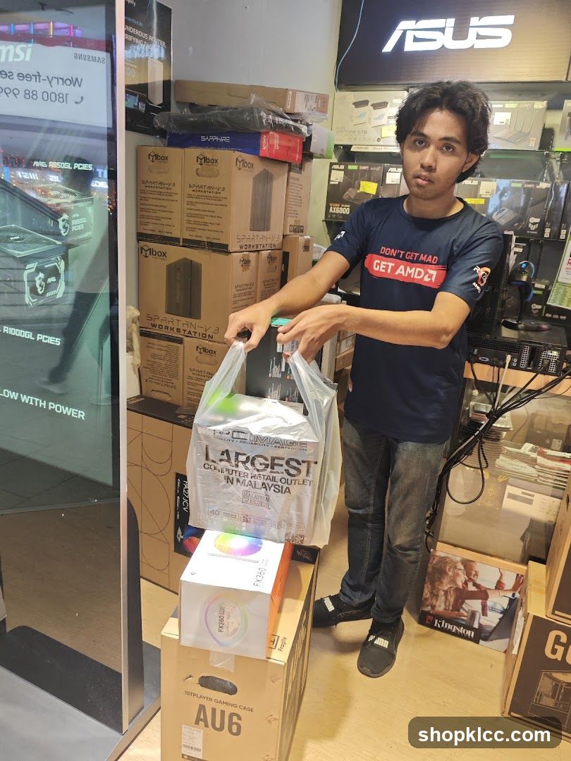 Man holding shopping bags in a computer store