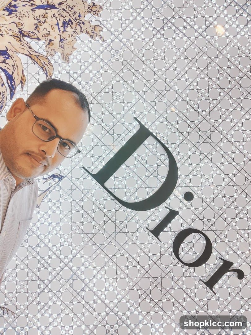 Man Posing in Front of Dior Logo