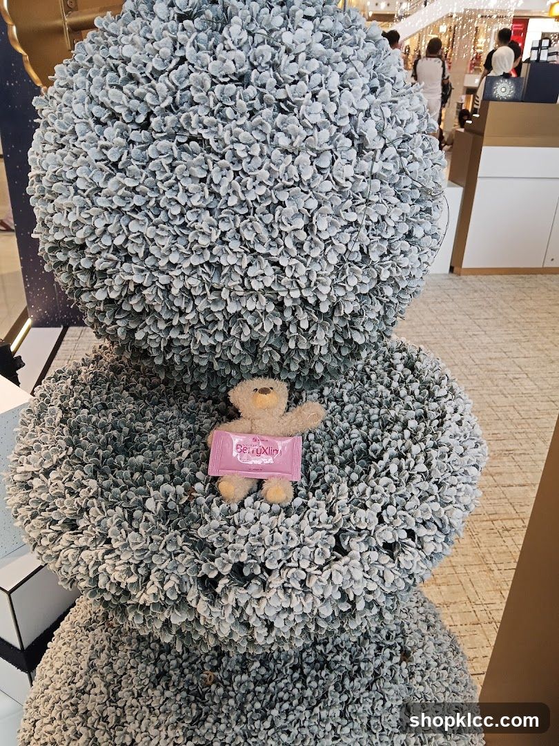 Teddy bear with product sample on decorative topiary