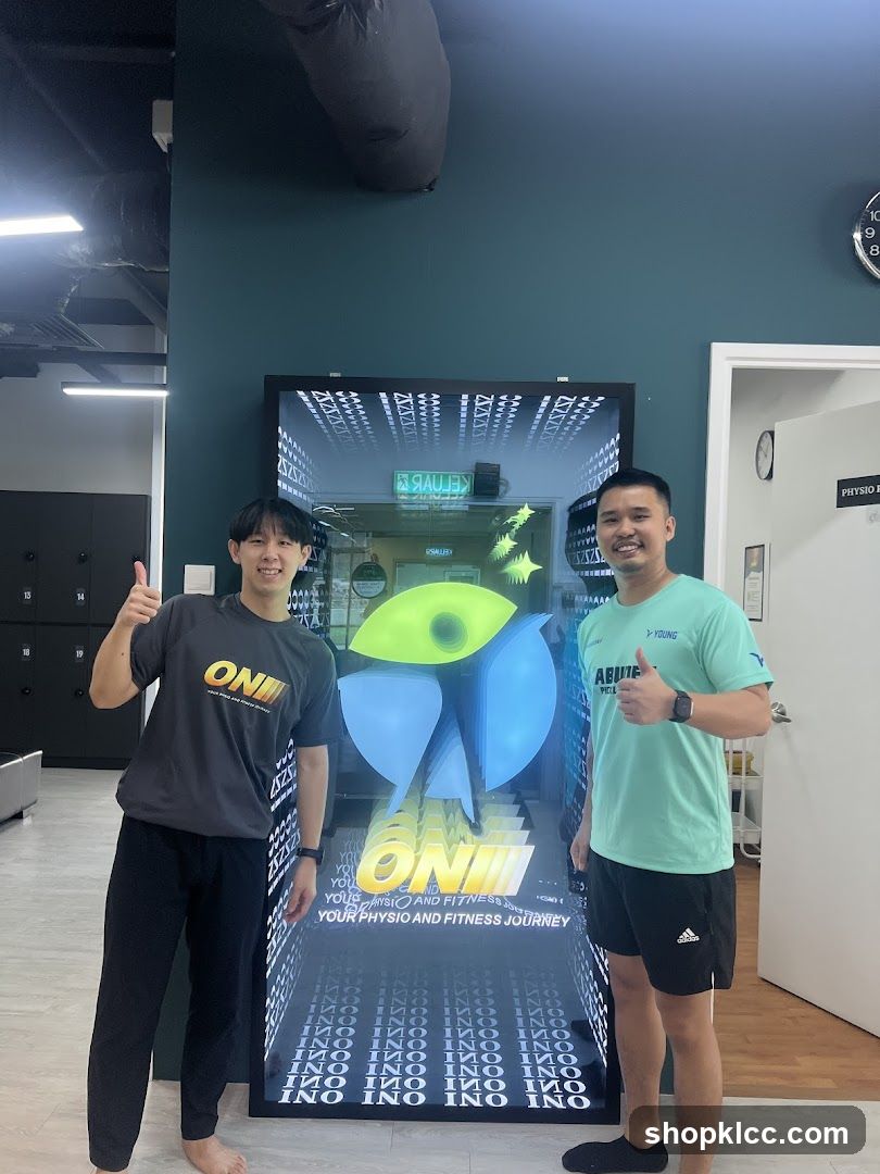 Two men posing in front of a digital display