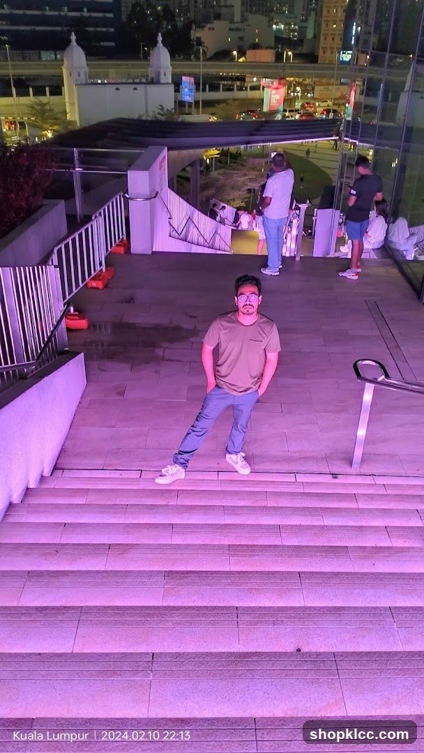 Man Posing on Illuminated Stairs at Night