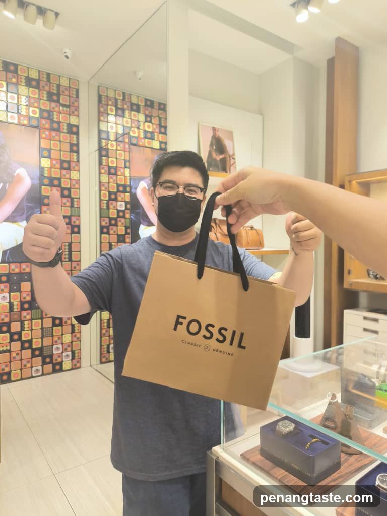 Man holding a Fossil shopping bag