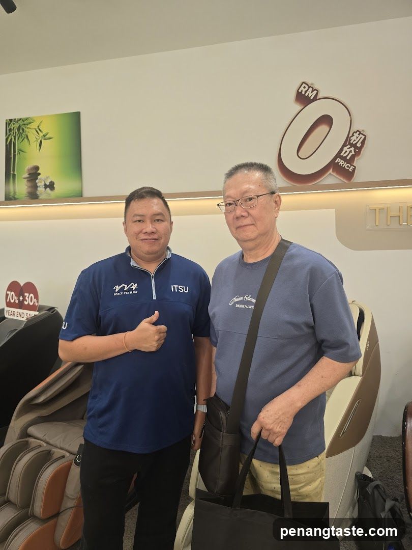 Two men posing in a store with massage chairs