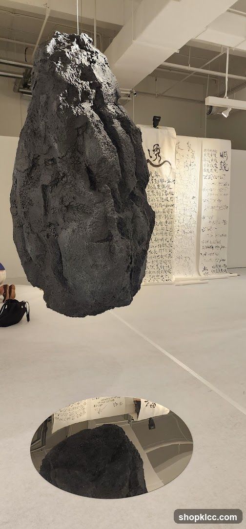 Art Installation with Suspended Rock and Calligraphy