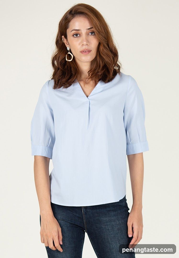 Woman in light blue blouse and dark jeans